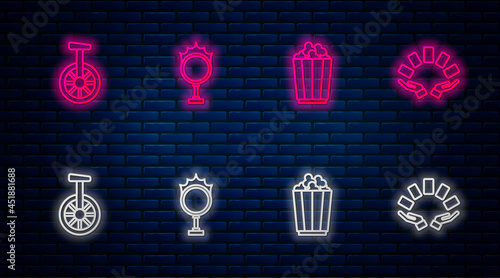Set line Circus fire hoop, Popcorn in box, Unicycle one wheel bicycle and Hand holding playing cards. Glowing neon icon on brick wall. Vector