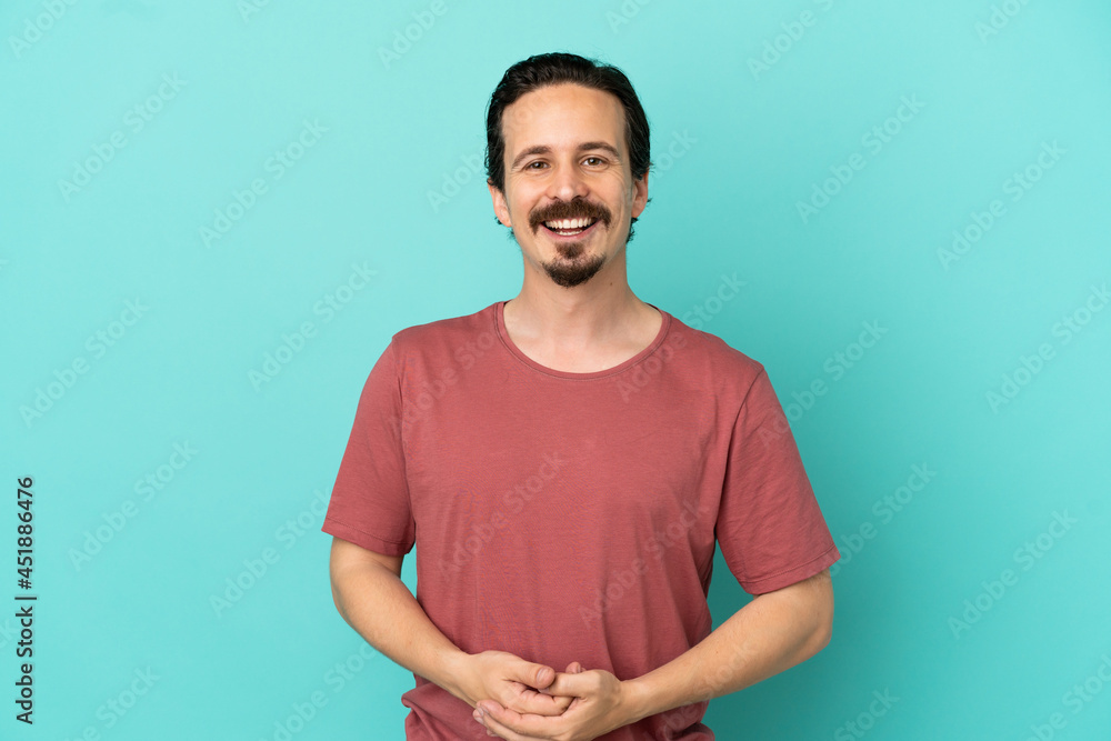 Young caucasian man isolated on blue background laughing Young caucasian man isolated on blue background laughing
