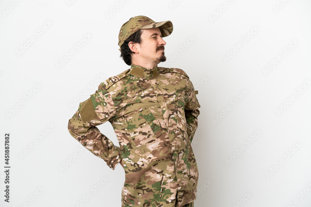 Soldier man isolated on white background suffering from backache for having made an effort Soldier man isolated on white background suffering from backache for having made an effort