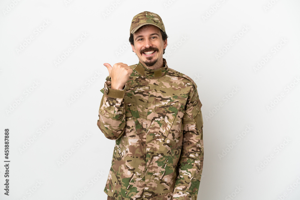 Soldier man isolated on white background pointing to the side to present a product Soldier man isolated on white background pointing to the side to present a product
