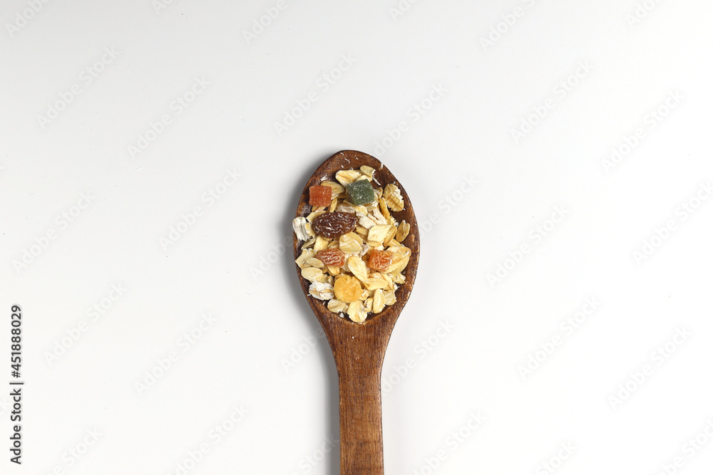 Breakfast cereals in wooden spoon. Healthy muesli with oat flakes, nuts and raisins isolated on white background. Breakfast cereals in wooden spoon. Healthy muesli with oat flakes, nuts and raisins isolated on white background.