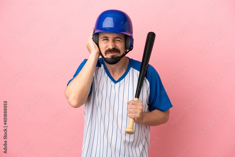 Young caucasian man playing baseball isolated on pink background frustrated and covering ears