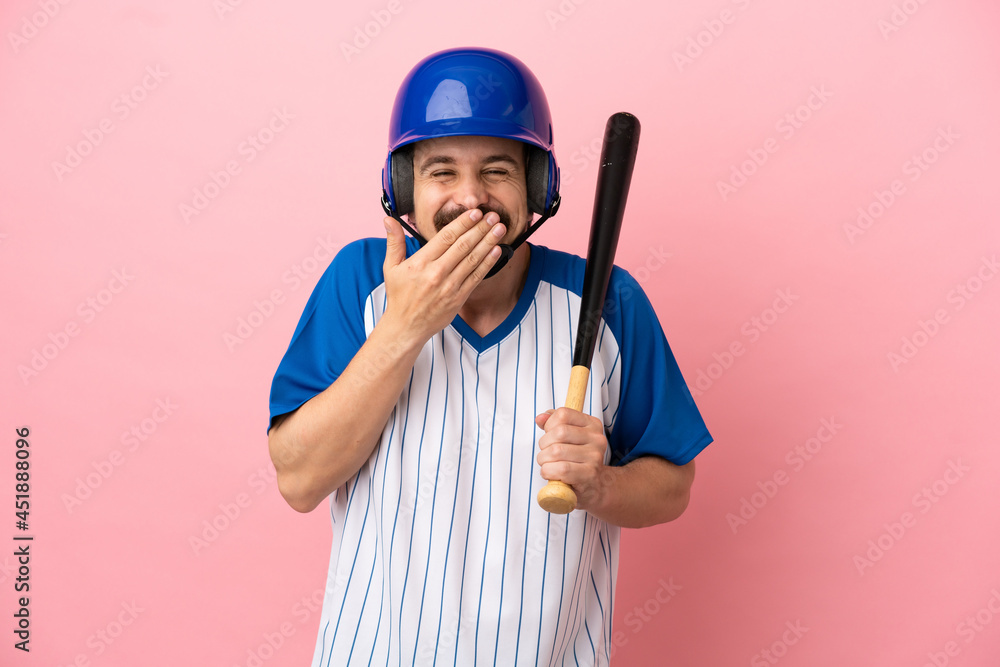 Young caucasian man playing baseball isolated on pink background happy and smiling covering mouth with hand Young caucasian man playing baseball isolated on pink background happy and smiling covering mouth with hand