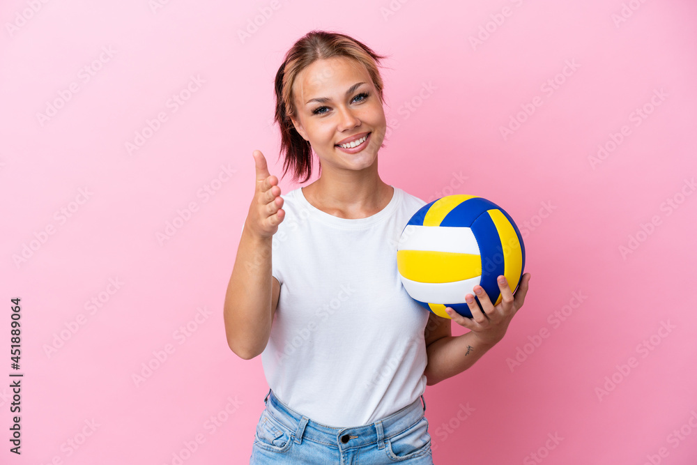 Young Russian woman playing volleyball isolated on pink background shaking hands for closing a good deal