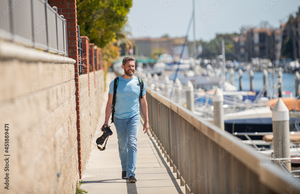 Vacation photographer. Travel photographer promenade holding camera. Summer traveller go sightseeing Vacation photographer. Travel photographer promenade holding camera. Summer traveller go sightseeing