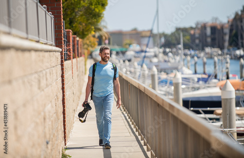 Vacation photographer. Travel photographer promenade holding camera. Summer traveller go sightseeing © Olena