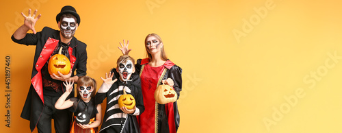 Family in Halloween costumes on color background with space for text photo
