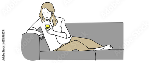 ソファでスマホ操作する女性