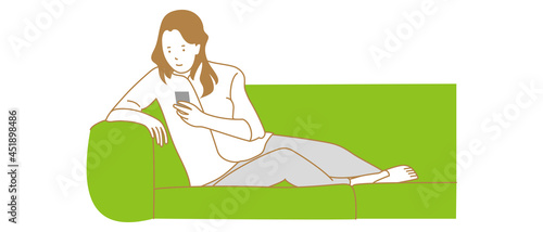 ソファでスマホ操作する女性