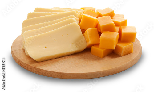 Fatias de queijo mussarela e cubos de queijo cheddar em tábua de madeira sobre fundo branco para recorte. photo