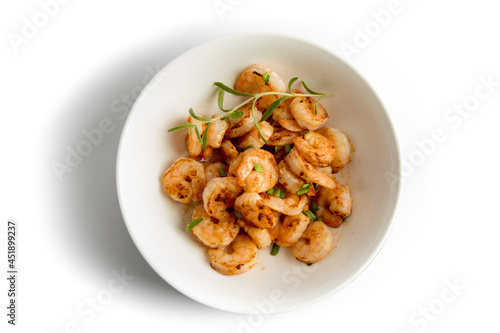 Top down view of Sauted shrimp in a bowl with green onions and isolated on white
