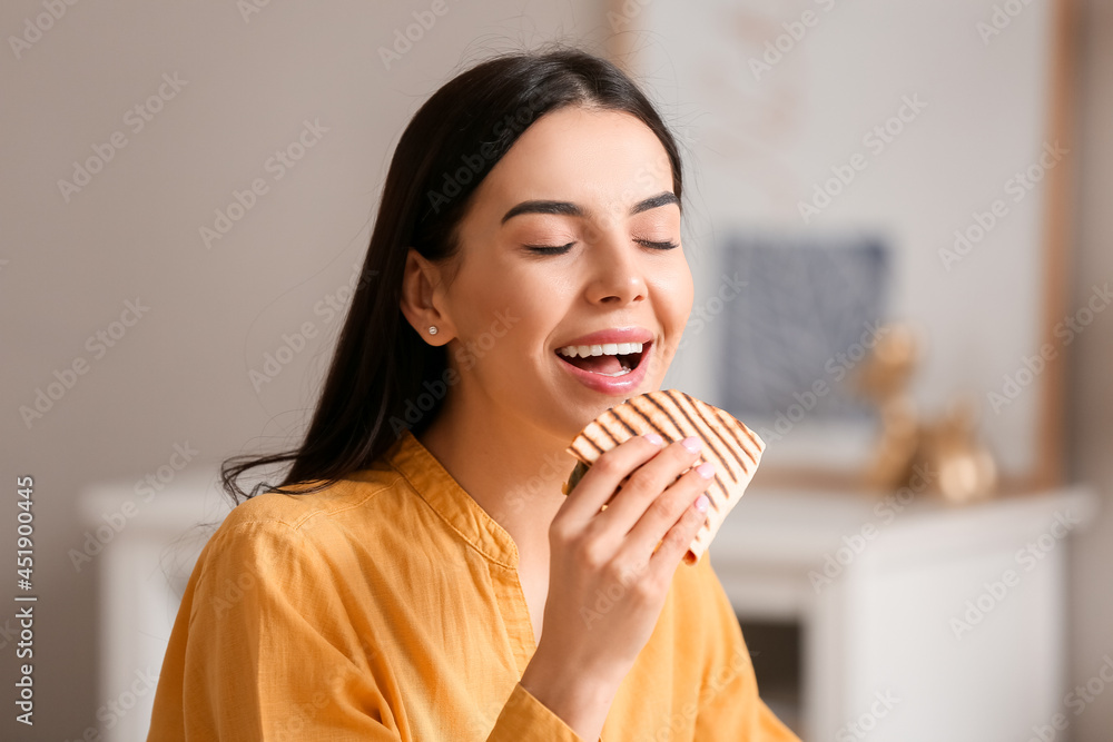 Beautiful young woman eating tasty quesadilla at home Beautiful young woman eating tasty quesadilla at home