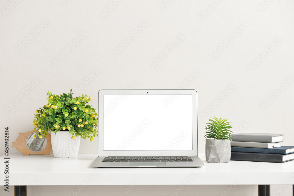 Fototapeta premium Modern laptop on table near color wall