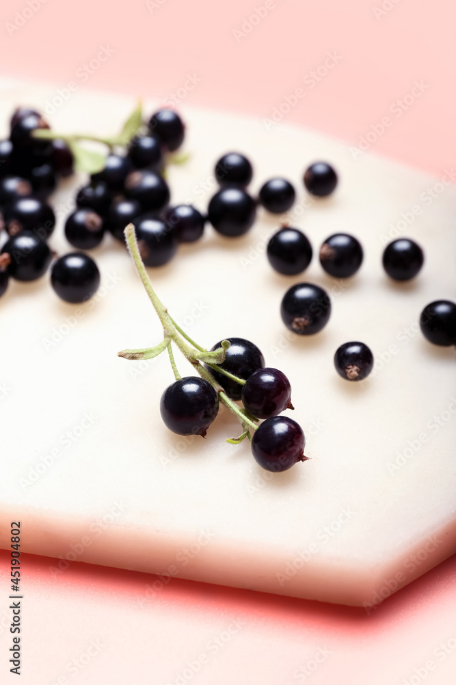 Board with ripe black currant on color background, closeup Board with ripe black currant on color background, closeup