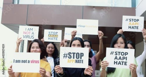 Group of mix age Asian women holding a paper with words during participants in Asian American Pacific Islanders rally marching protest for anti-racial and ask to stop hate on AAPI citizen.