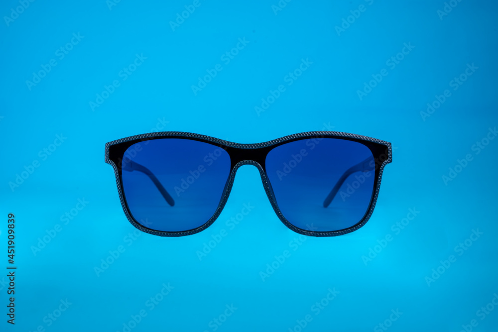 Sun Glasses with blue glass and black frame on blue background Sun Glasses with blue glass and black frame on blue background