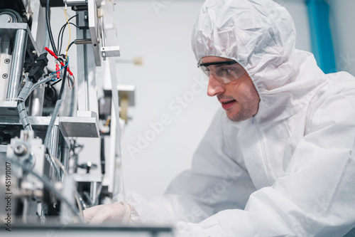 Scientists wearing protective clothing Inspect mask making machines in a laboratory at an industrial plant. Anti-virus production warehouse. concept of safety and prevention coronavirus covid-19.
