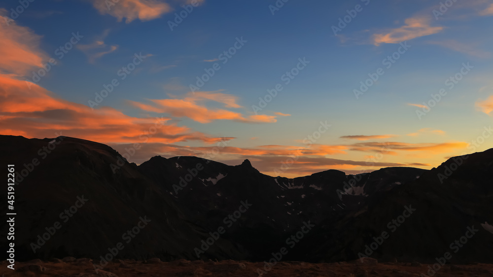 Rocky mountain peaks with colorful sky after sunset