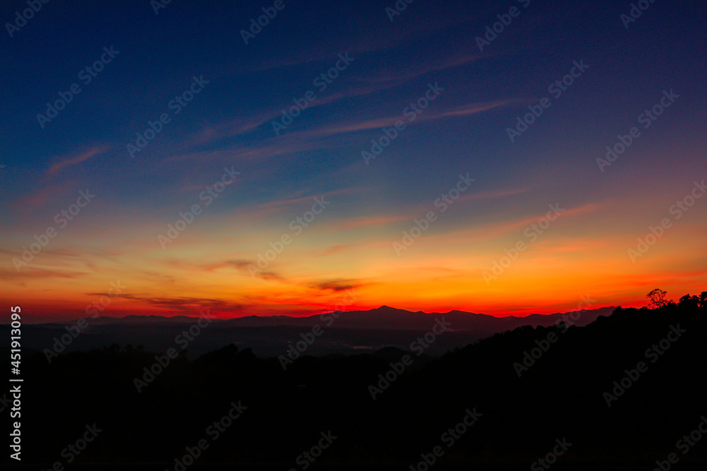 sunrise or sunset with mountain. Orange and blue sky background.