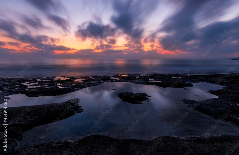 amazing scenic view at a sea shore from a coast after dramatic colorful sunset with flying blured clouds and reflection on water surface , beautiful ocean landscape amazing scenic view at a sea shore from a coast after dramatic colorful sunset with flying blured clouds and reflection on water surface , beautiful ocean landscape