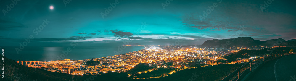 Fototapeta premium Terracina, Italy. Top View Skyline Cityscape City In Evening Night Illuminations. Panorama, Panoramic View