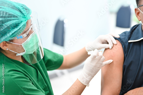 close up doctor s hand injecting for vaccination in the shoulder man patient.Vaccine for protection covid-19 Corona virus  infection.Vaccination for coronavirus treatment.Prevention infectious.