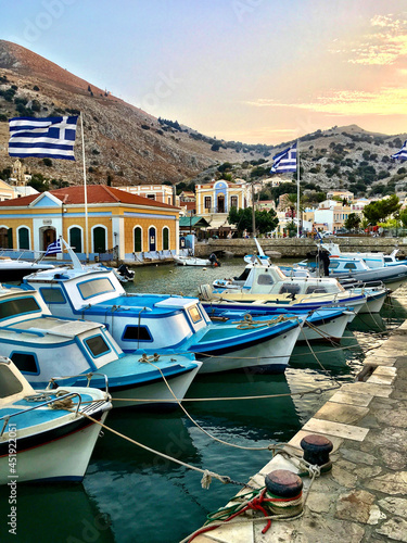 Vertical shot of boats standing in Symi Ano, Greece coast photo