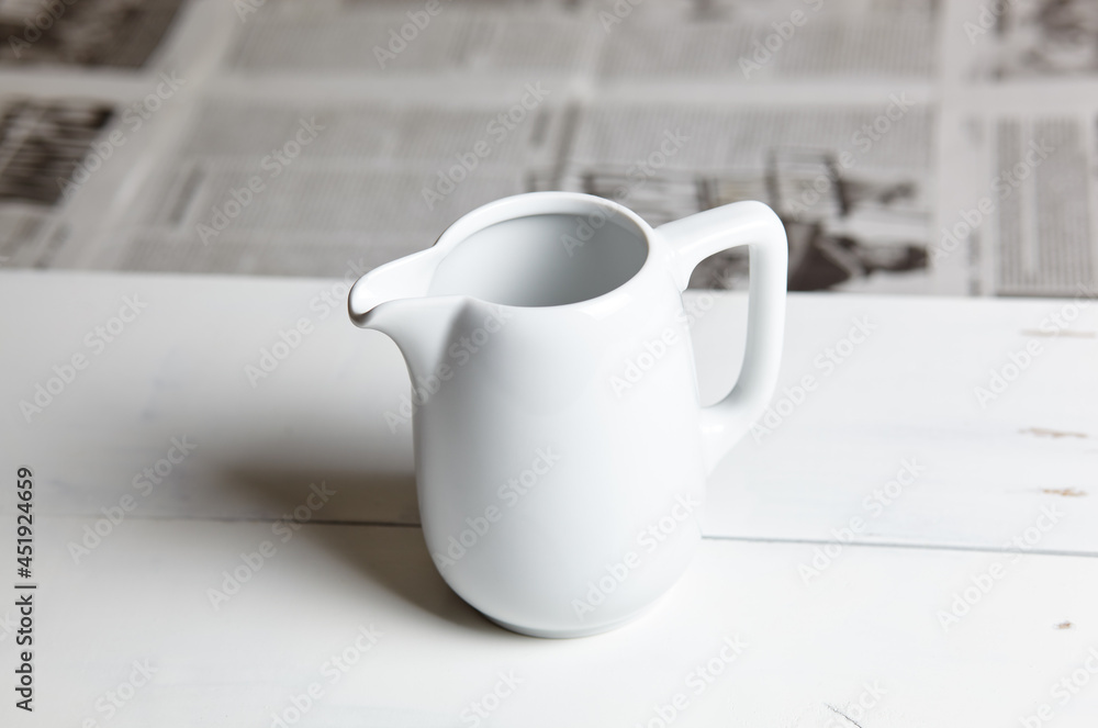 Empty milk jug on wooden background. Porcelain sauce boat, pitcher, creamer or ceramic gravy boat Empty milk jug on wooden background. Porcelain sauce boat, pitcher, creamer or ceramic gravy boat