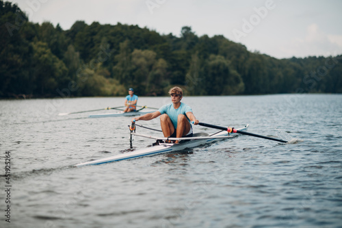 Sportsman oarsman single scull man rower rowing on boat oars.