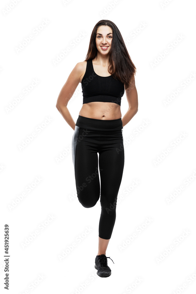 Young woman in black sportswear practices yoga. Sports and active lifestyle. Full height. Isolated on white background. Vertical. Young woman in black sportswear practices yoga. Sports and active lifestyle. Full height. Isolated on white background. Vertical.