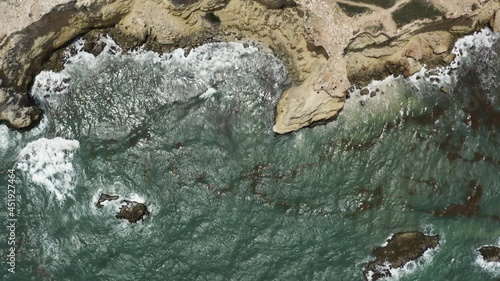 Birdseye view looking down over green seas and the rugged clifftops and old lighthouse at Morrillos Wildlife refuge in Cabo Puerto Rico on the Caribbean Sea. photo