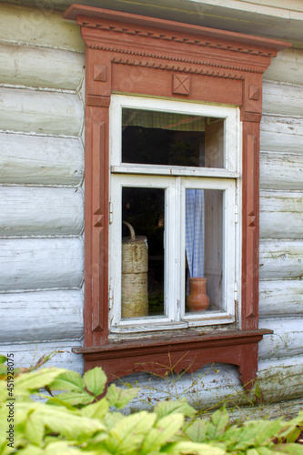 antique window in a country house with white curtains and a vase of flowers open unbuttoned in summer close-up vintage