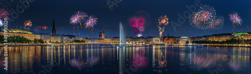 Panorama view of citycenter from Alster Lake,view to Hamburg Rathaus and fountain in the center of the lake with fireworks. Festive atmosphere with fireworks in Hamburg. Port birthday in Hamburg. photo