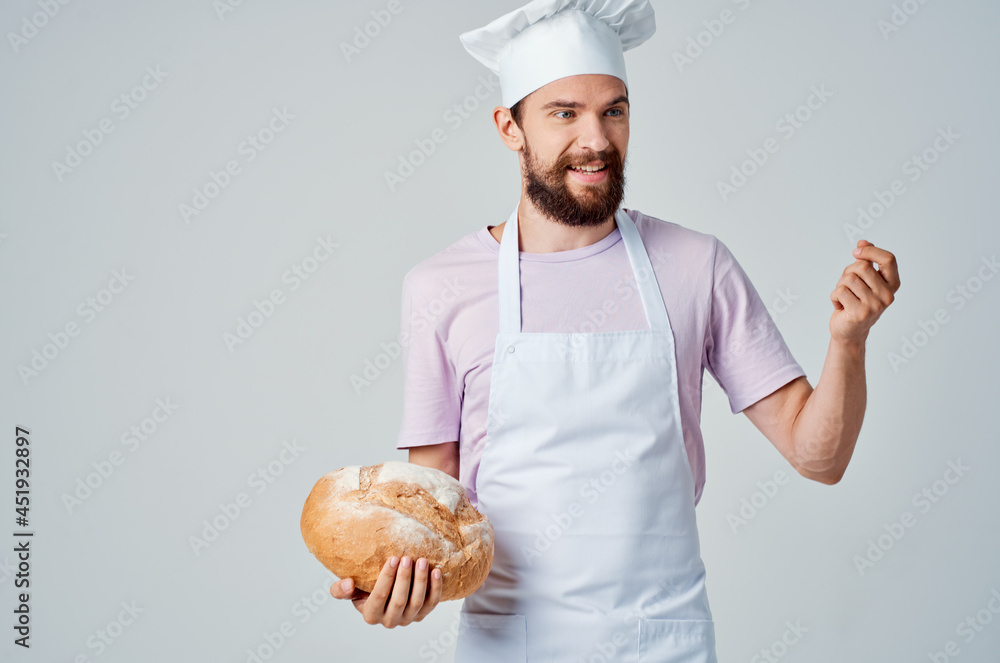 emotional Baker in a White apron with bread in his hands Professional emotional Baker in a White apron with bread in his hands Professional