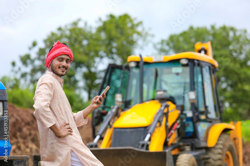 Indian farmer using smartphone at his field