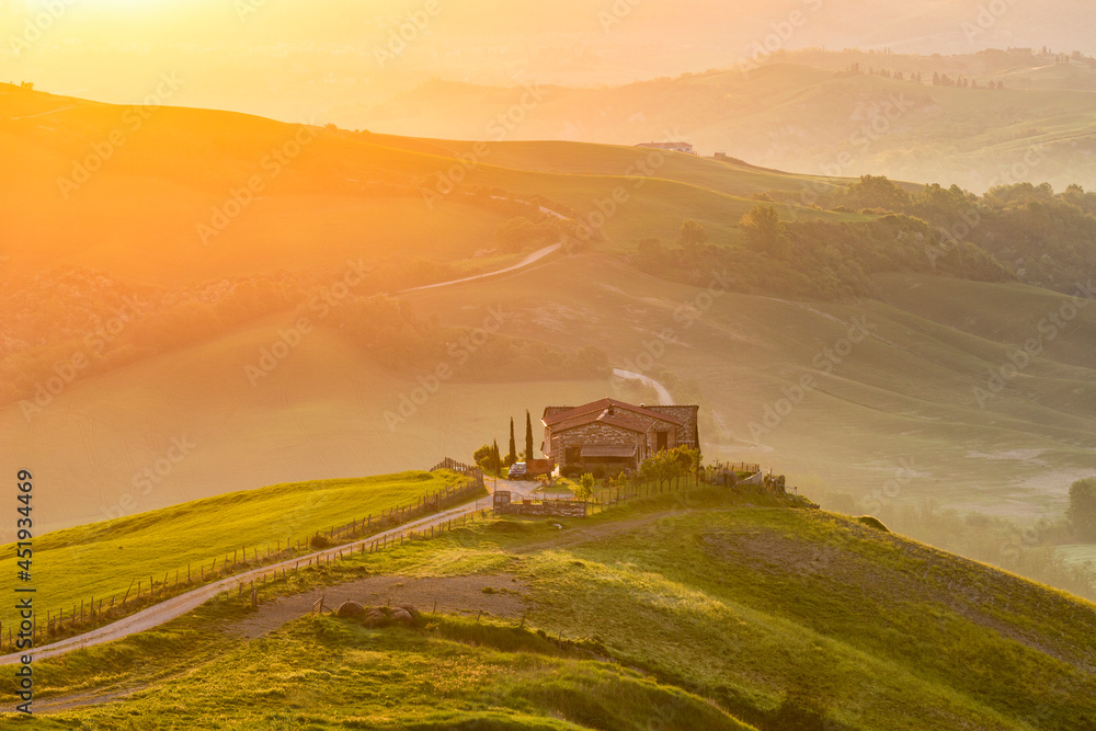 Naklejka premium Country house on a hill in the valley at sunrise