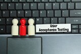 laptop keyboard, peg doll, colored board with the word user acceptance testing
