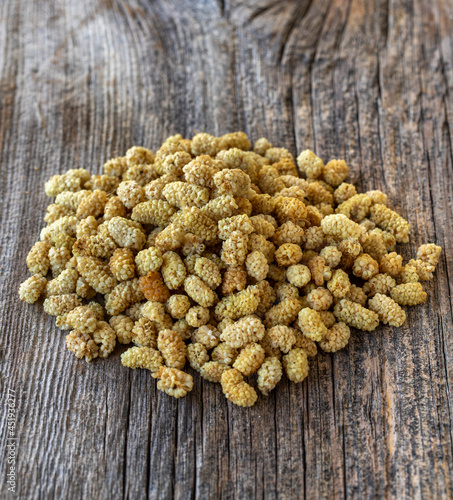 Dried mulberry. Dried mulberry nuts on wood background. Bulk dried mulberry grains