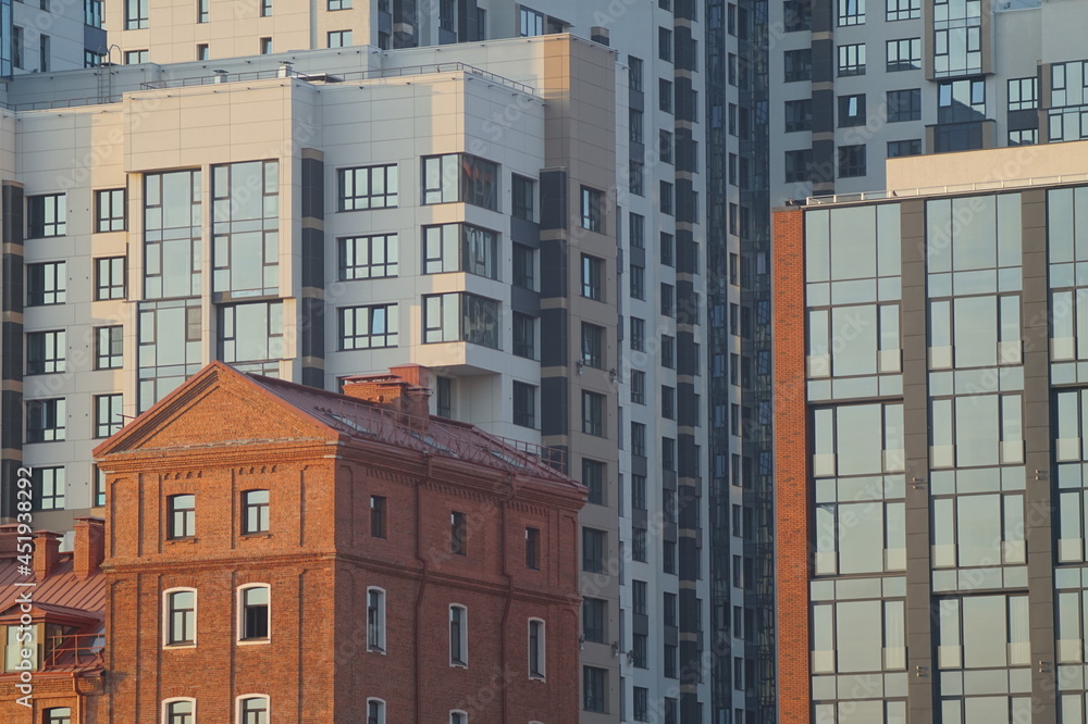 Photo of a part of the facades of modern buildings. Urban landscape at sunset. A pile of glass, concrete and brick. Photo of a part of the facades of modern buildings. Urban landscape at sunset. A pile of glass, concrete and brick.