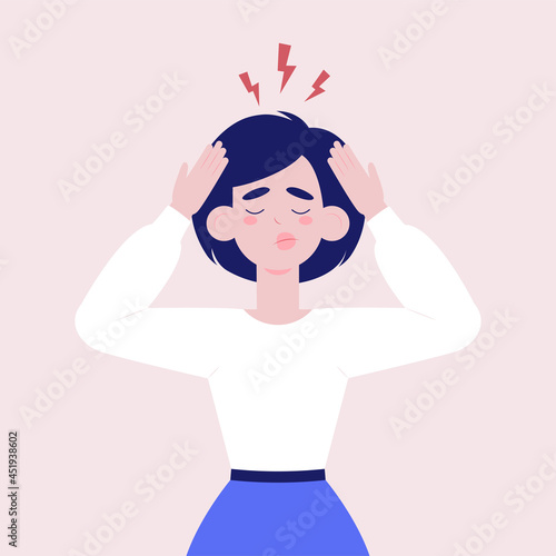 Woman holding her head with two hands while experiencing headache or depression