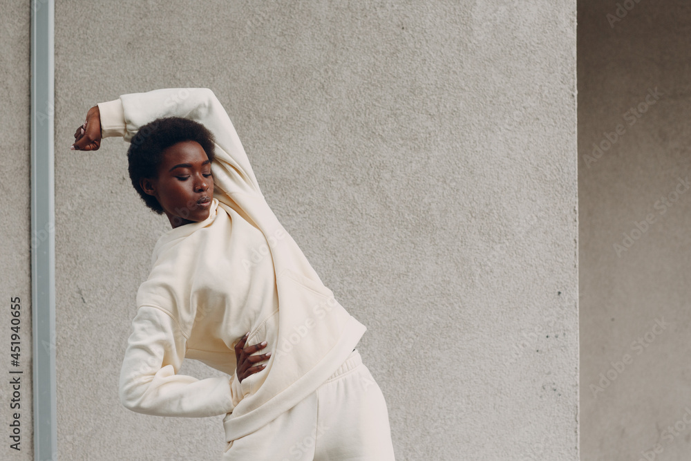 Young african american woman stretching and warming up outdoor street wall. Fitness and outside sport healthy lifestyle concept. Young african american woman stretching and warming up outdoor street wall. Fitness and outside sport healthy lifestyle concept.