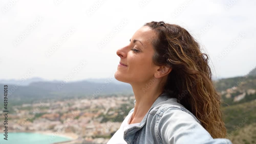 Horizontal view of woman with opened arms breathing fresh air in a cliff on holidays. Freedom summer concept. Happy woman traveling and sightseeing across Europe. Horizontal view of woman with opened arms breathing fresh air in a cliff on holidays. Freedom summer concept. Happy woman traveling and sightseeing across Europe.