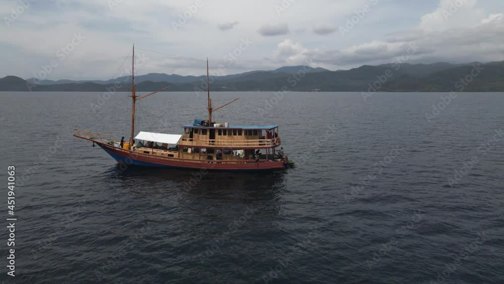 Drone Orbiting At Wooden Boat Carrying Tourists Sailing At Calm Ocean In Bali, Indonesia. - aerial Drone Orbiting At Wooden Boat Carrying Tourists Sailing At Calm Ocean In Bali, Indonesia. - aerial