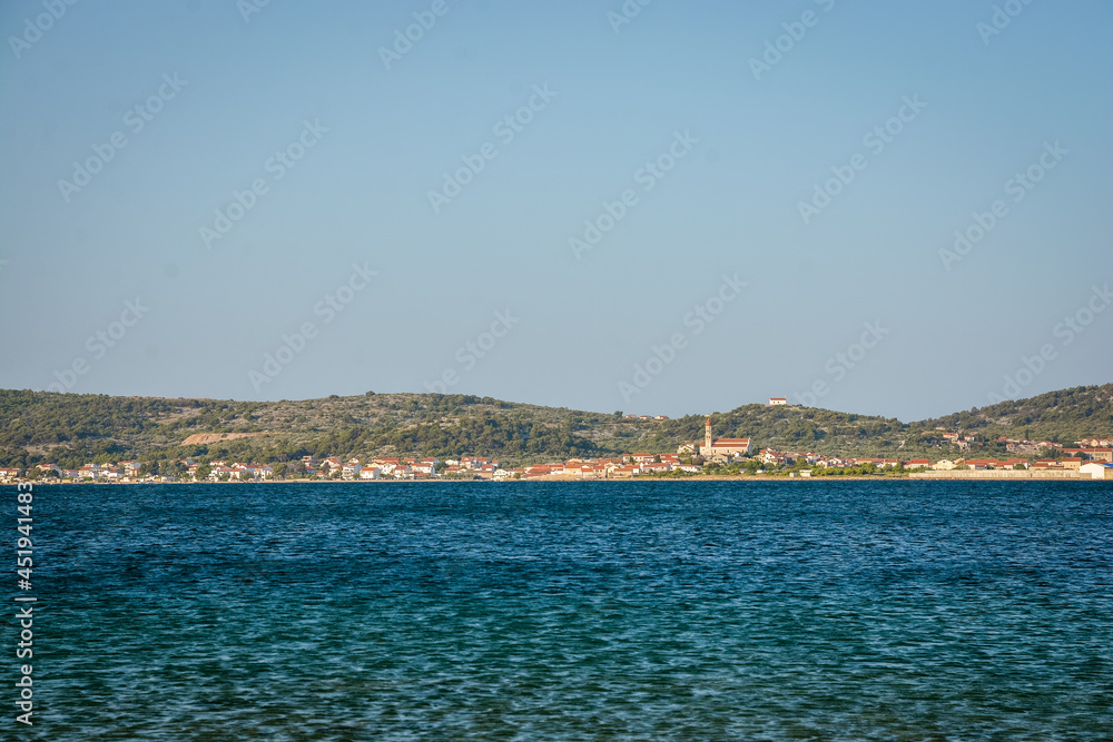 Landscape view of the city of Murter in summer in Croatia with calm blue water in the foreground
