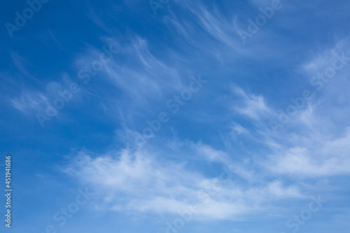 The bright blue sky and white clouds.
