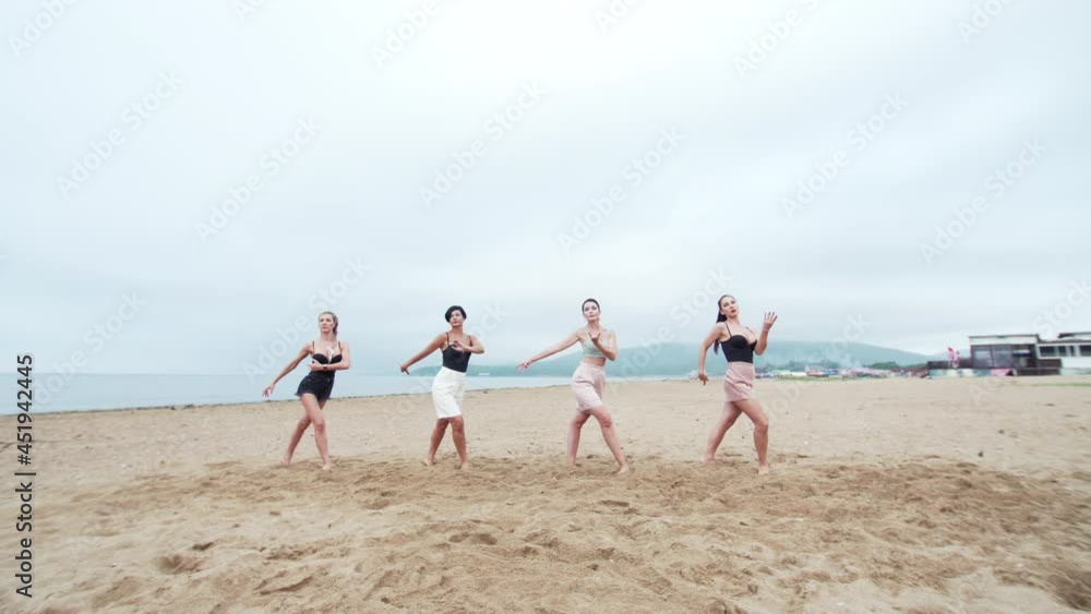 Four attractive women are dancing on the sandy beach in the morning. Group of ladies are dancing in sexy way Four attractive women are dancing on the sandy beach in the morning. Group of ladies are dancing in sexy way