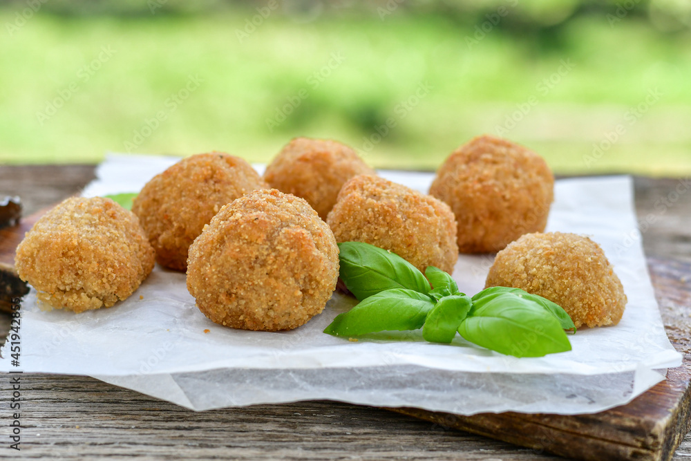 Italian arancini Cacio e pepe. Home-made rice balls with mozzarella cheese, parsley, lemon, and parmesan cheese.