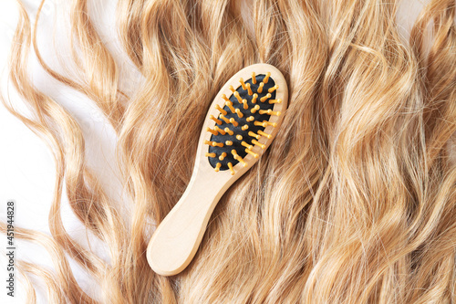 Photos Blond female wavy hair and bamboo comb brush