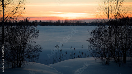 Winter landscape of snow field with snowdrift on sunset background