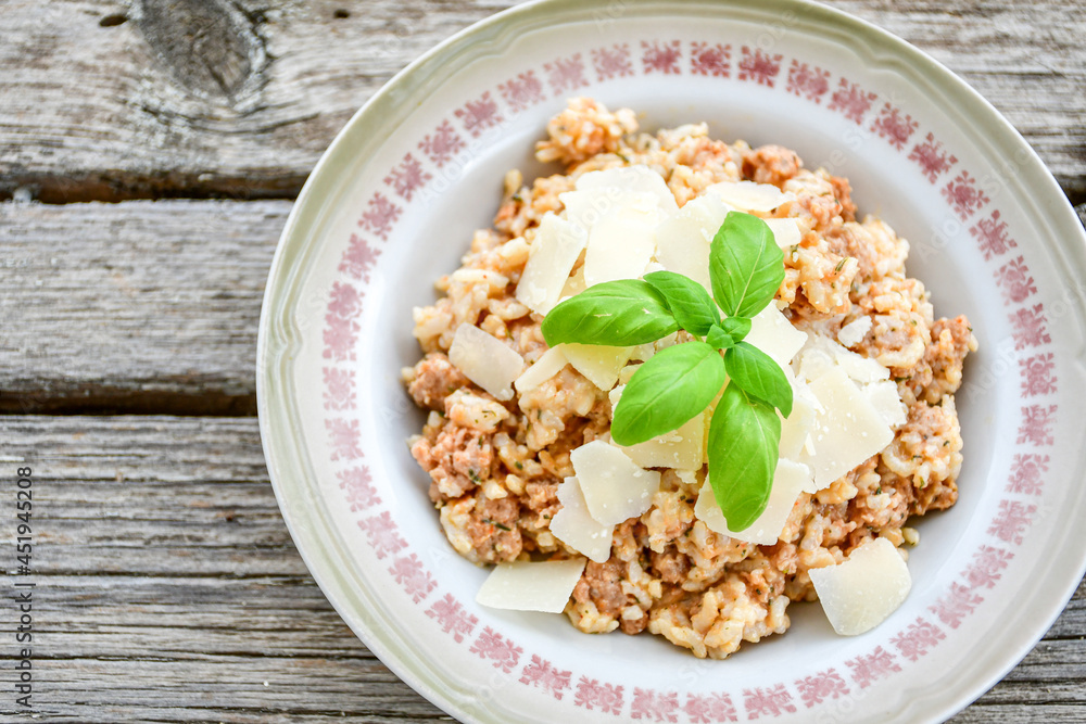 Italian bolognese risotto with parmesan cheese on rustic background Italian bolognese risotto with parmesan cheese on rustic background